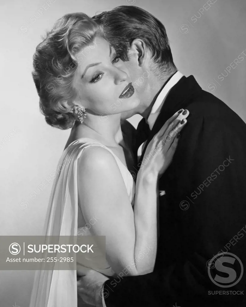 Side profile of mid adult couple embracing