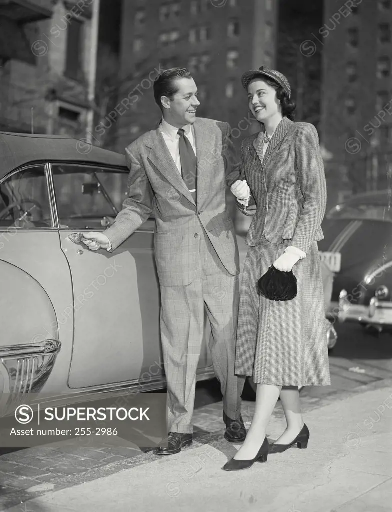 Vintage photograph. Man opening car door for his date