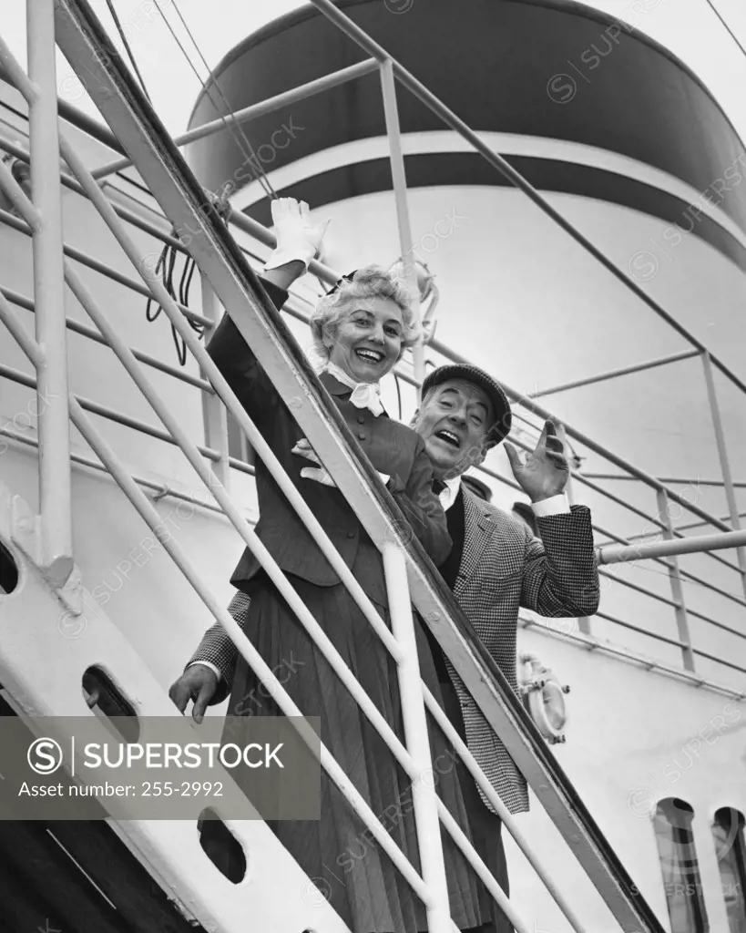 Portrait of a senior couple waving from a ship