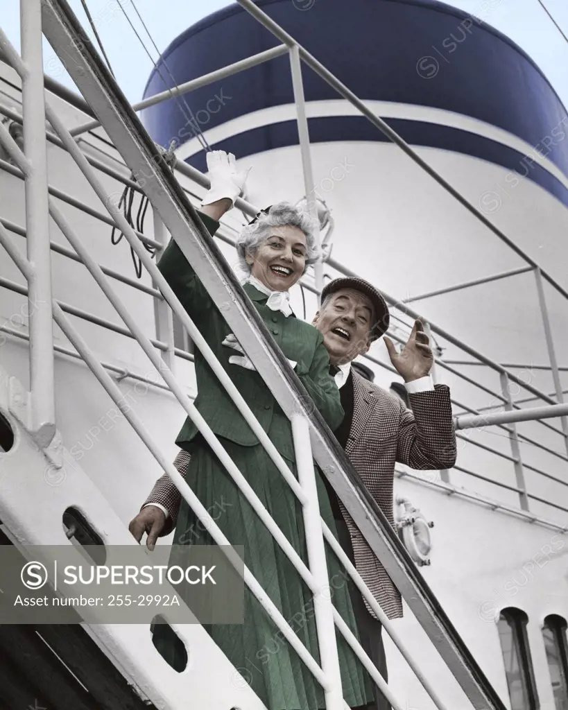 Portrait of senior couple waving from ship