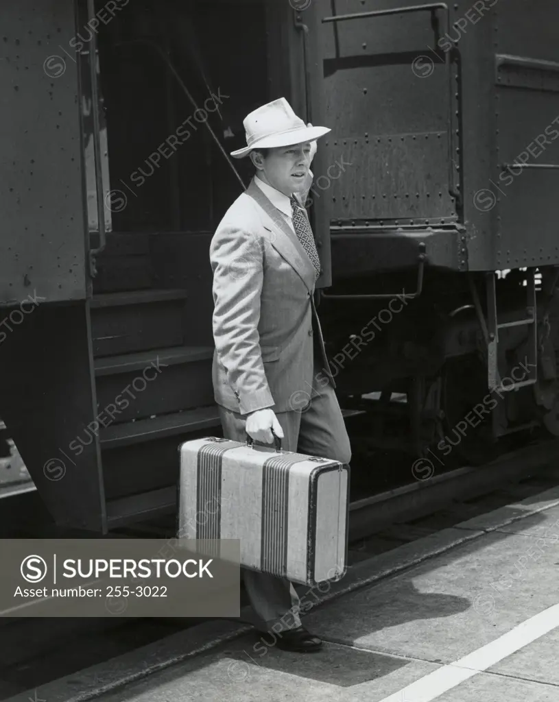 Side profile of a young man carrying a briefcase