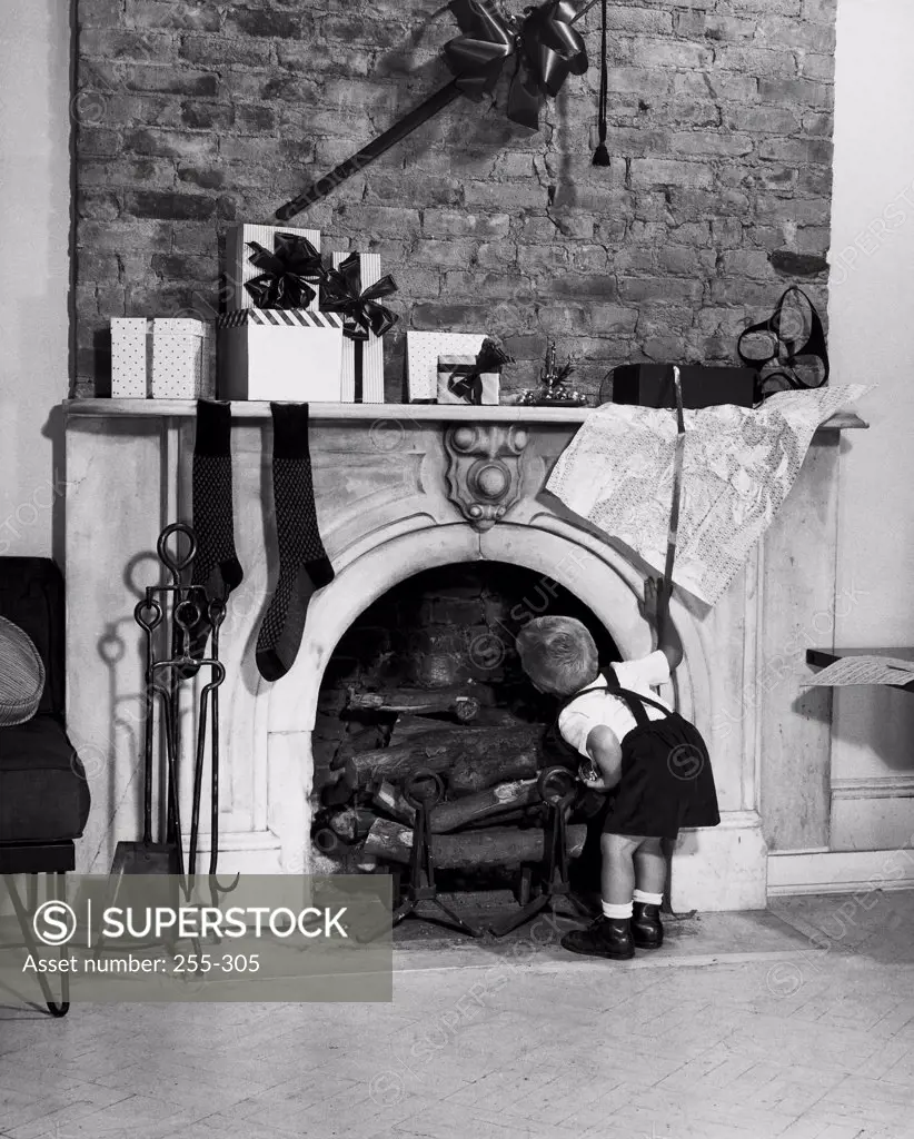 Rear view of a boy peeping into a fireplace