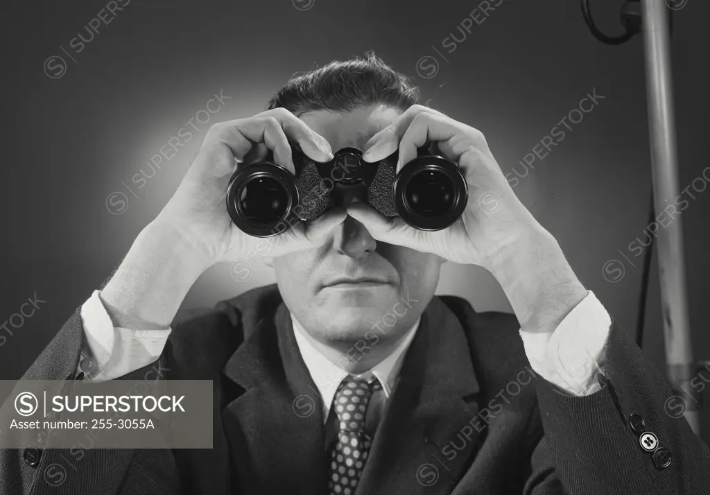 Vintage Photograph. Man in suit and tie looking through binoculars. Frame 2