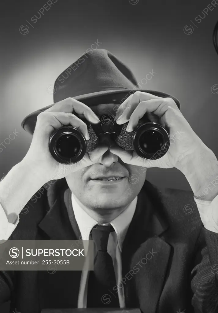 Vintage Photograph. Man wearing hat and looking through binoculars. Frame 1