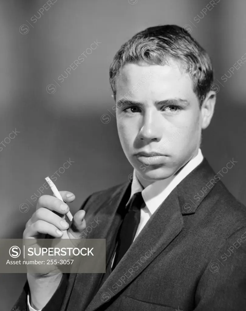 Close-up of a teenage boy smoking a cigarette