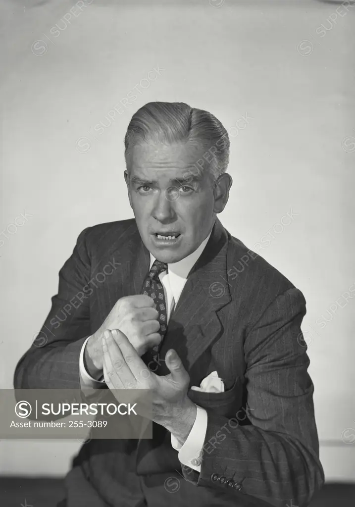 Vintage Photograph. Man in suit with stern expression slamming fist into hand