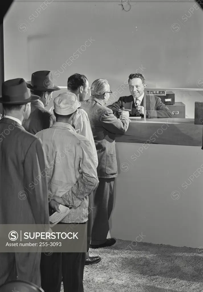 Vintage Photograph. Men standing in line waiting for the teller.