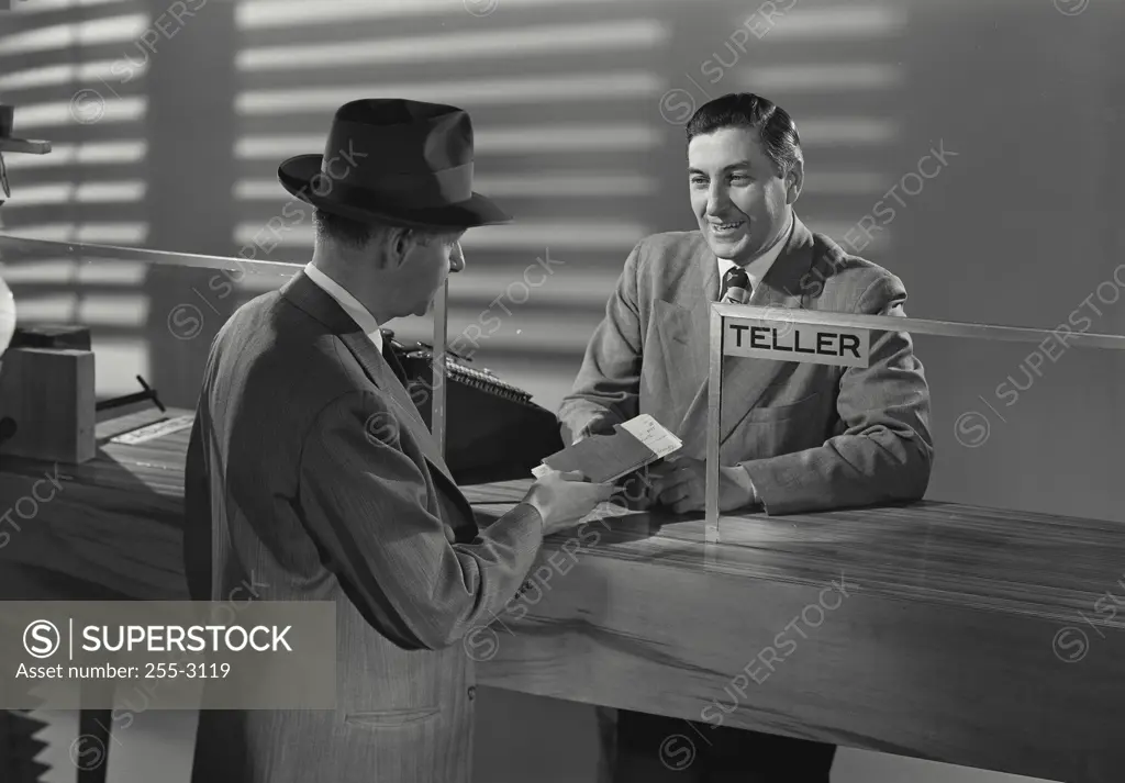 Vintage Photograph. Man at bank speaking with smiling bank teller