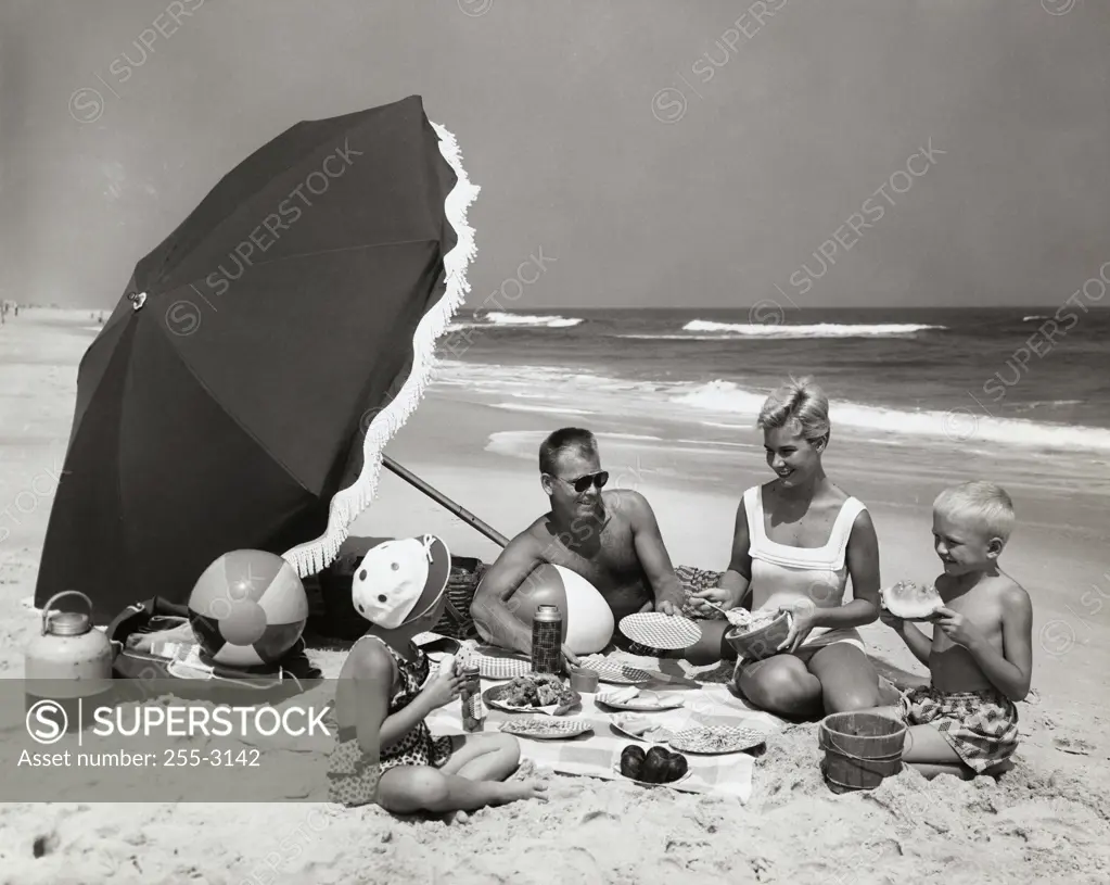 Parents and their two children having a picnic on the beach