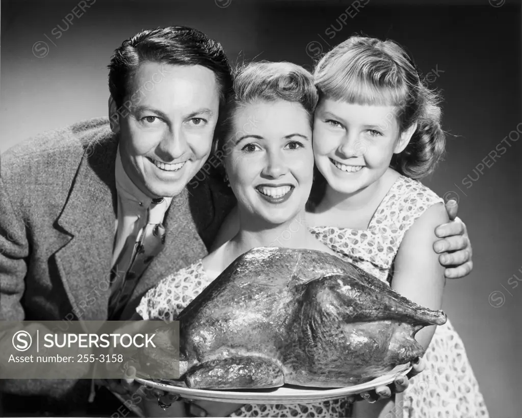 Portrait of a family with a turkey on a platter