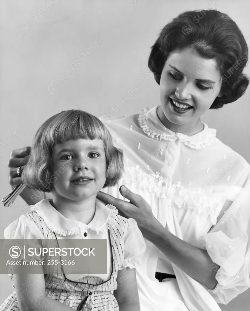 Mother brushing her daughter's hair