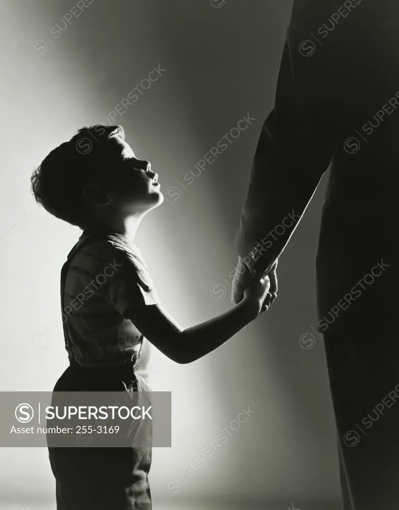 Side profile of a son holding his father's hand