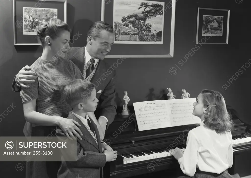 Vintage Photograph. Familywatching daughter play the piano. Frame 1