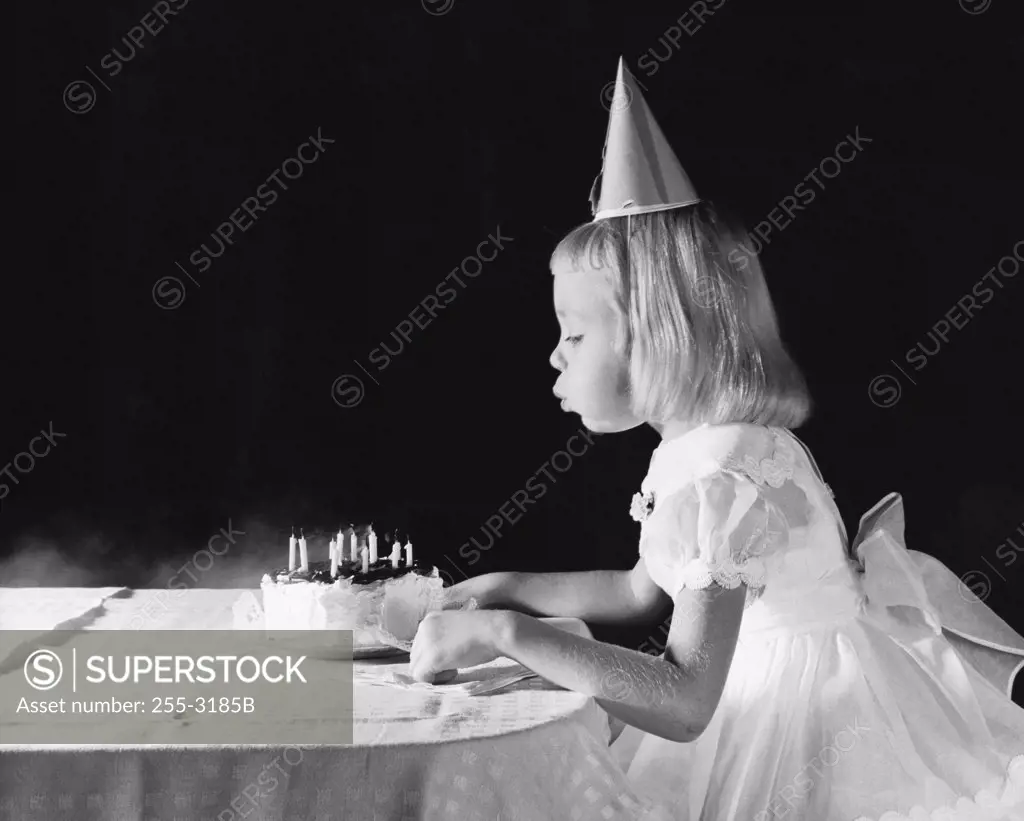 Girl blowing out candles on a birthday cake