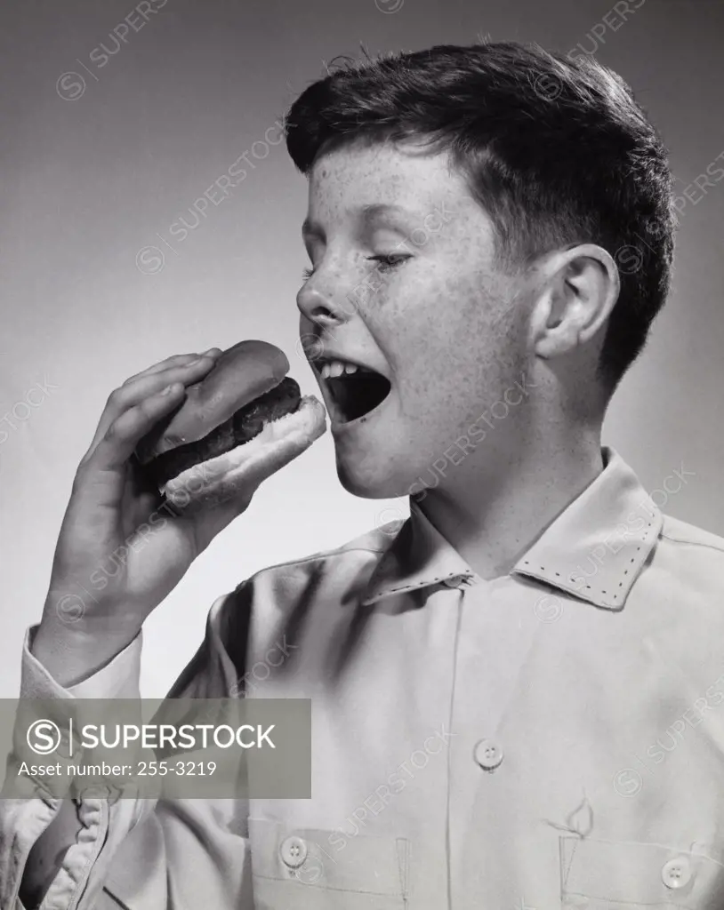Close-up of a boy eating a burger