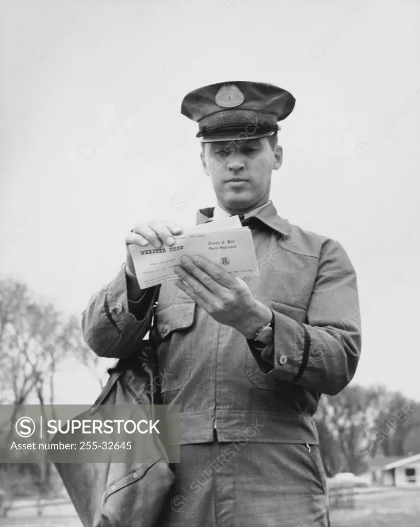 Close-up of a postman holding mail