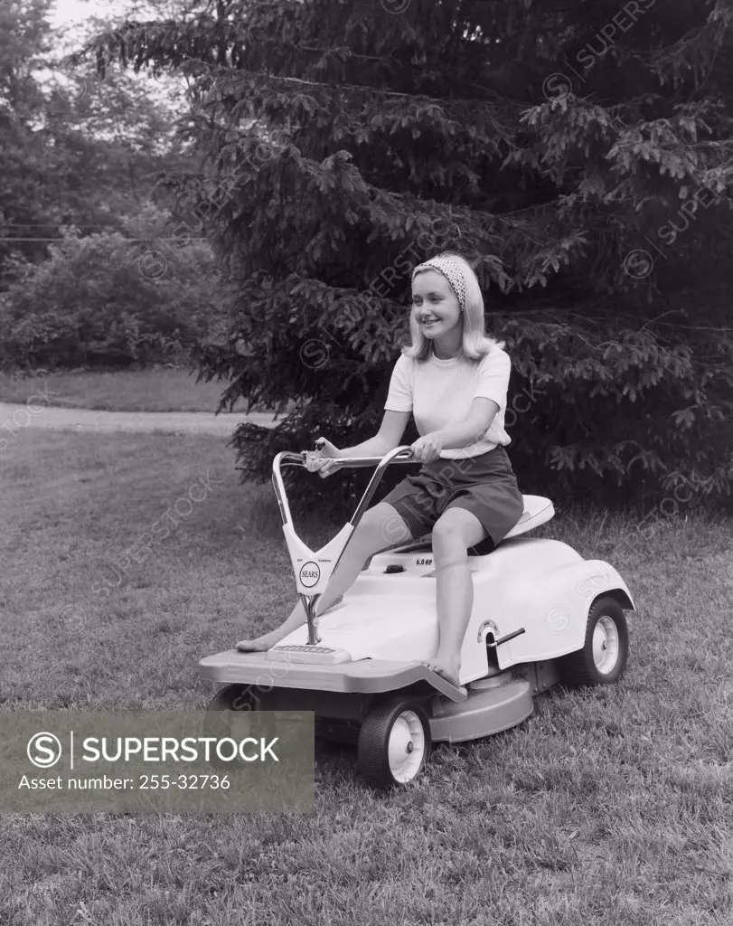 Young woman riding a lawn mower