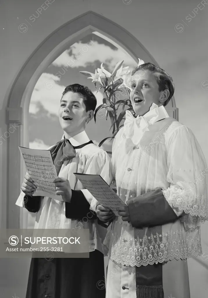Vintage photograph. Two altar boys holding sheet music while singing