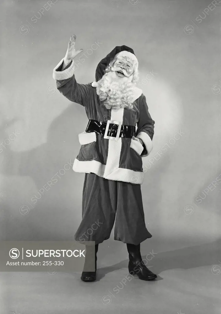 Vintage photograph. Portrait of man in Santa Claus costume smiling with hand raised