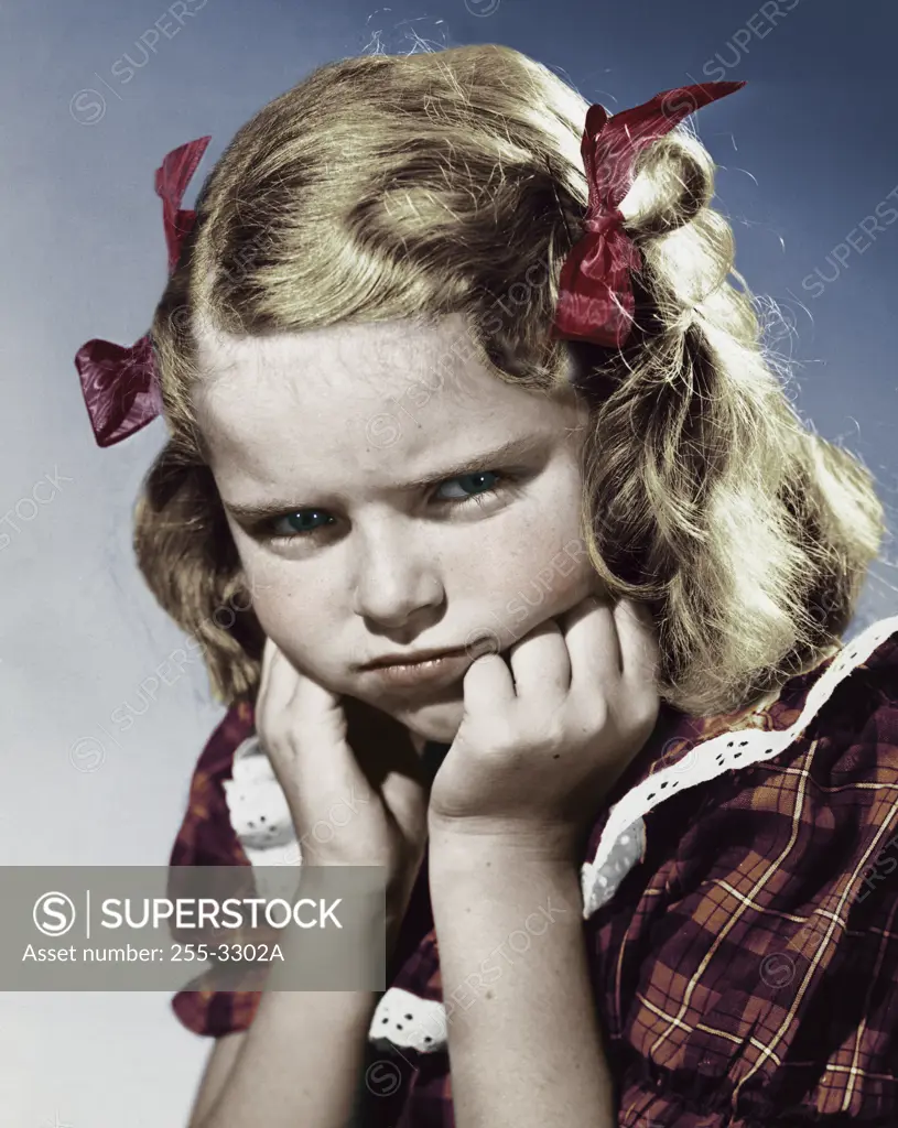 Colorized Vintage Photograph. Young girl making pouty expression with hands on chin