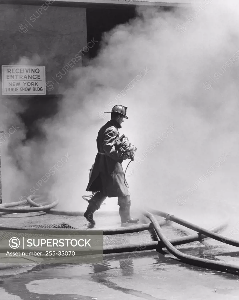 Firefighter walking in front of smoke