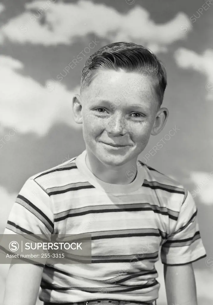 Vintage photograph. Portrait of a young boy with freckles in striped shirt looking at camera