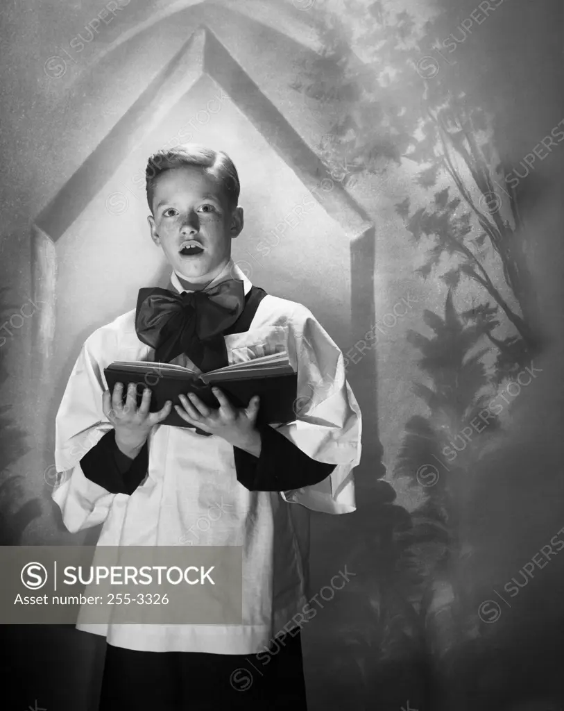 Choir boy holding a book and singing