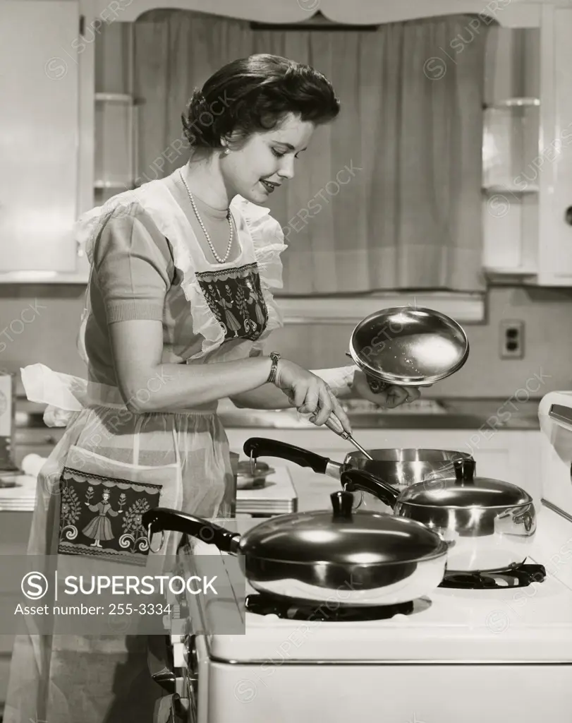 Side profile of a young woman cooking food in the kitchen