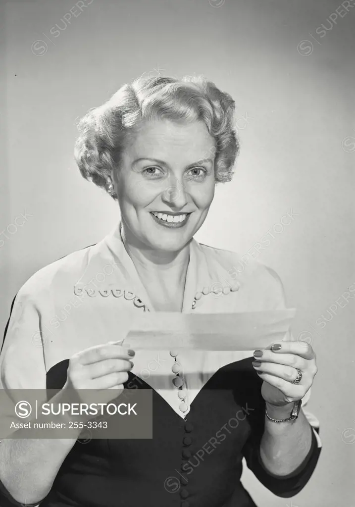 Vintage photograph. Woman in collared blouse smiling and reading paper