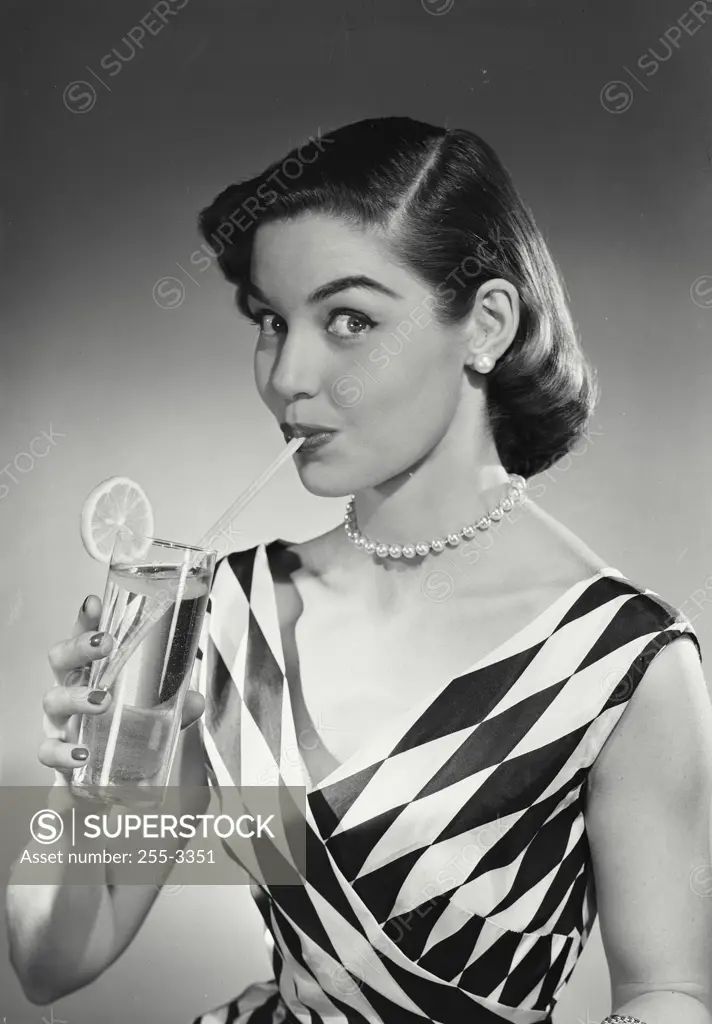 Vintage Photograph. Model in checkered blouse sipping beverage