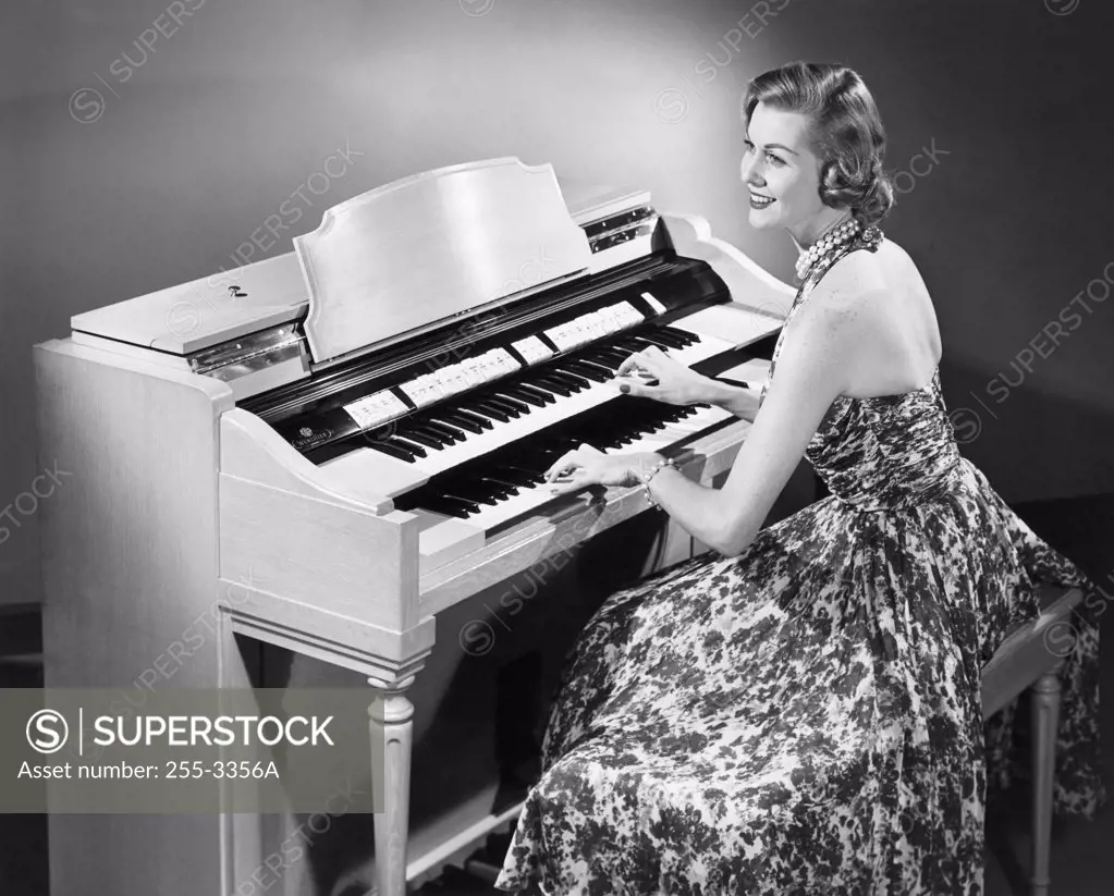 Side profile of a young woman playing an organ