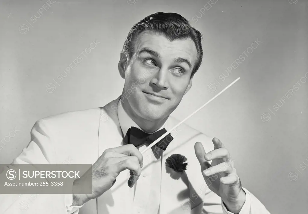 Vintage photograph. Close-up of a music conductor looking away waving baton