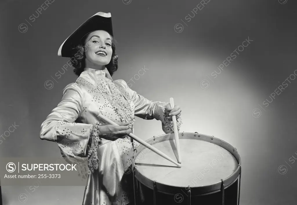 Vintage Photograph. Woman in long gown playing the drum. Frame 2