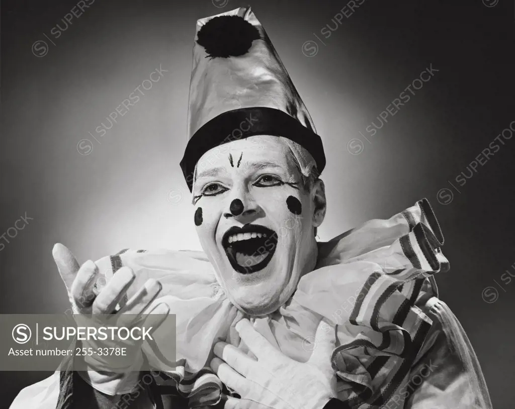 Vintage photograph. Portrait of clown in silly hat with excited expression.