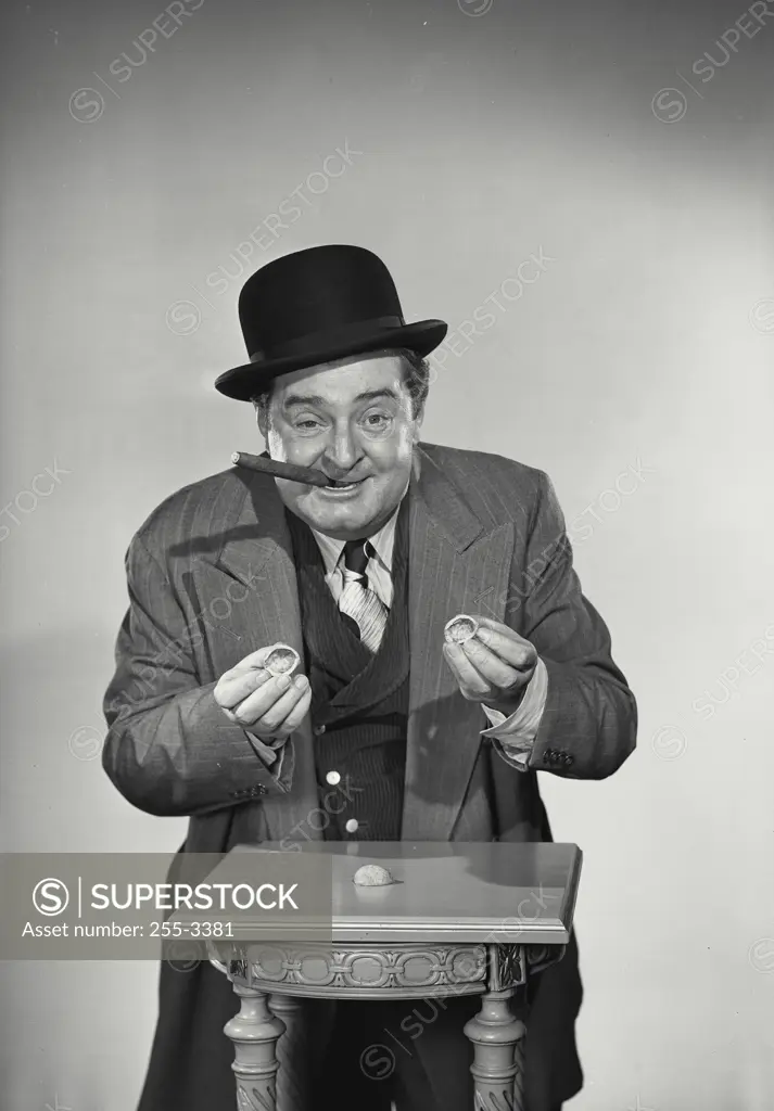 Vintage Photograph. Street gambler with cigar in mouth holding shells of nuts for game