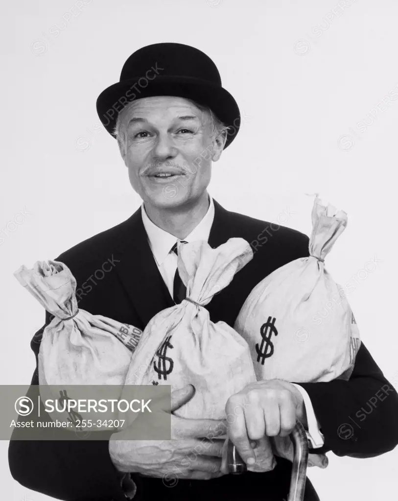 Portrait of a businessman holding three bags of money