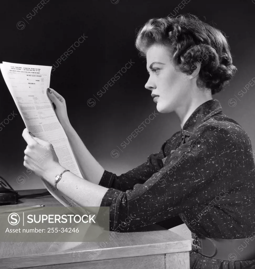 Side profile of a young woman reading a form