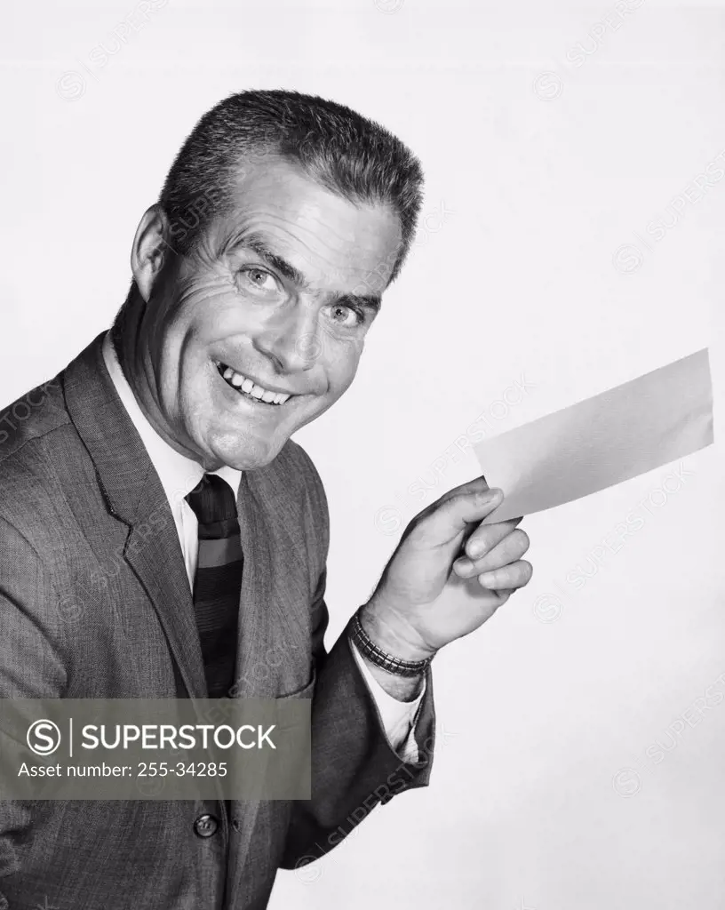 Portrait of a businessman holding a sheet of paper and smiling
