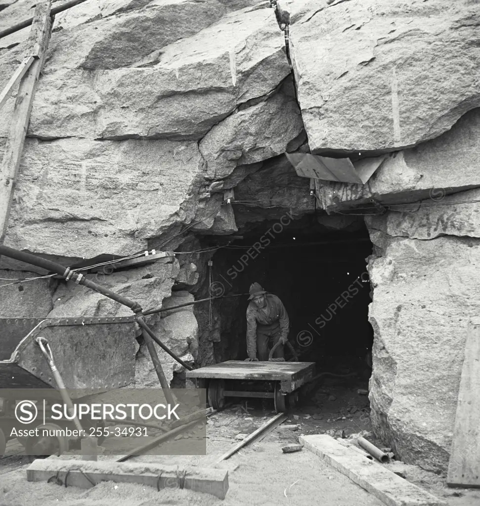 Vintage photograph. Miner pushing a cart at the entrance to a rock mine in Peekskill, New York