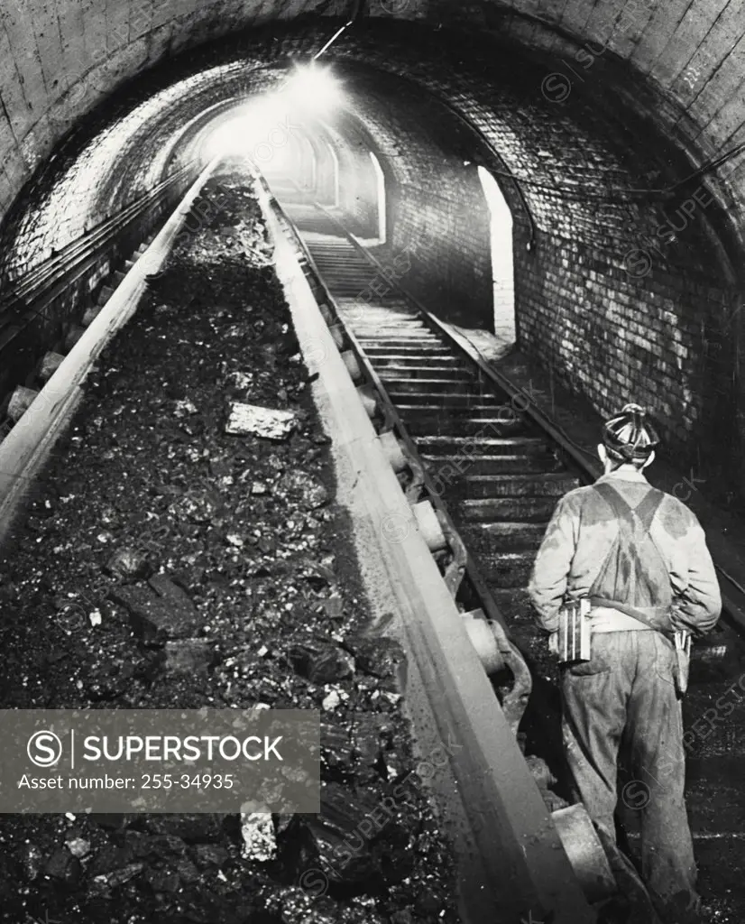 Vintage photograph. Rear view of a coal miner standing at the railroad track in a pit mine, Robena Mine, Pennsylvania, USA