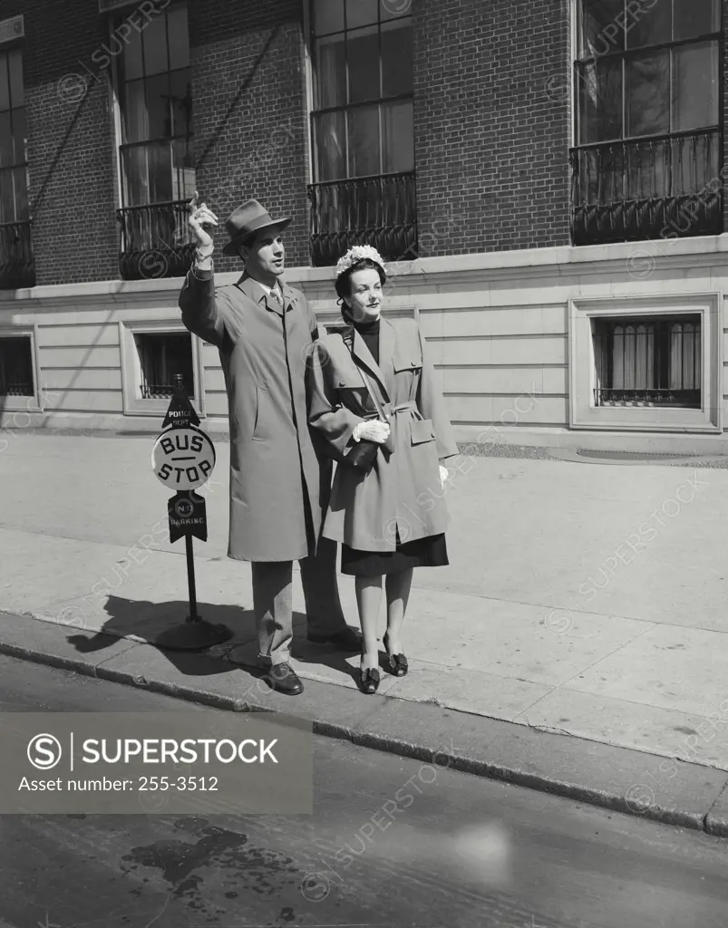 Vintage Photograph. Young man and a young woman waiting at a bus stop