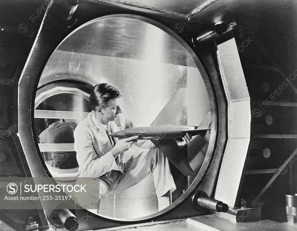 Vintage photograph. Engineer of the National Advisory Committee for Aeronautics inspects a test missile inside NACA's 4 x 4 foot supersonic wind tunnel