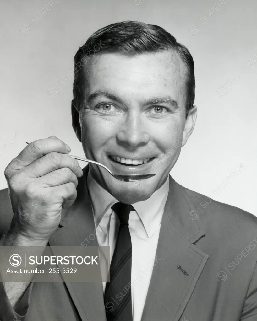 Portrait of a businessman eating with a spoon