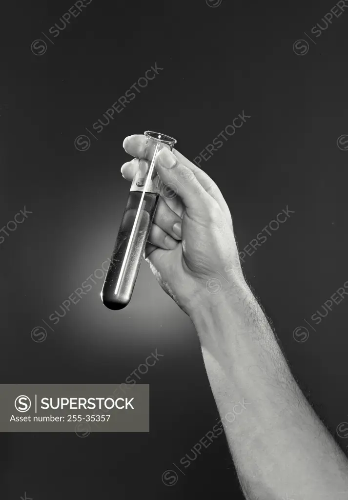 Vintage photograph. Man's hand holding a test tube of chemical