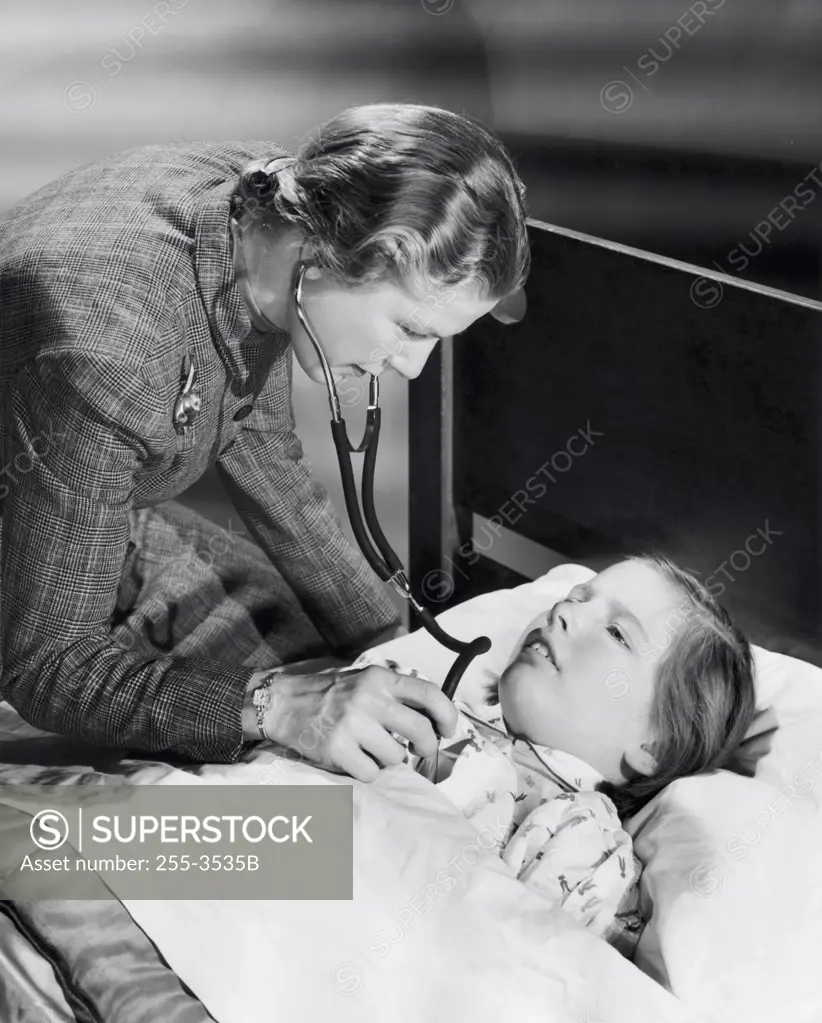 Female pediatrician examining a girl with a stethoscope