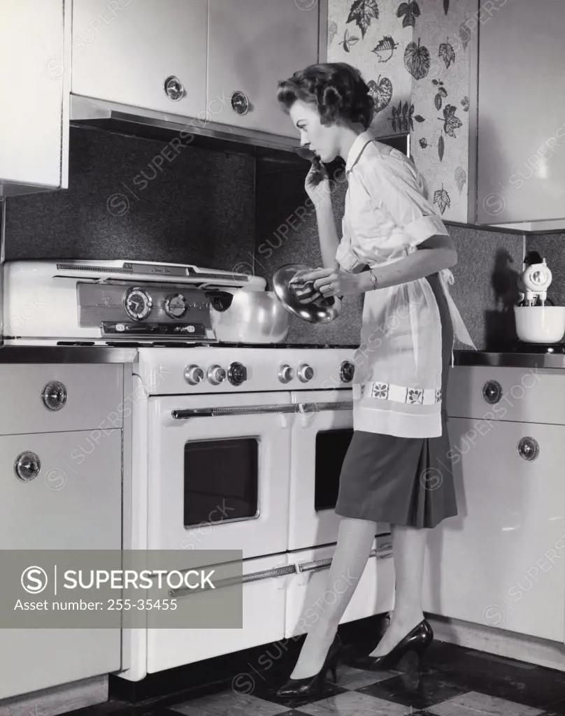 Mid adult woman cooking food in the kitchen