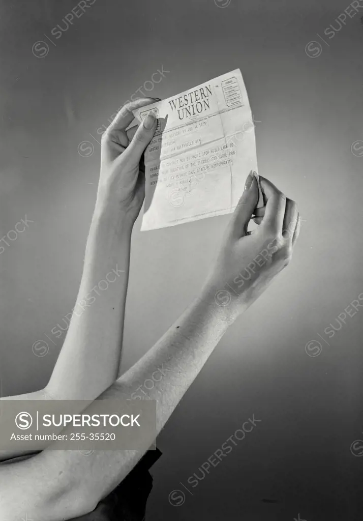 Vintage photograph. Close-up of a woman's hands holding a telegram