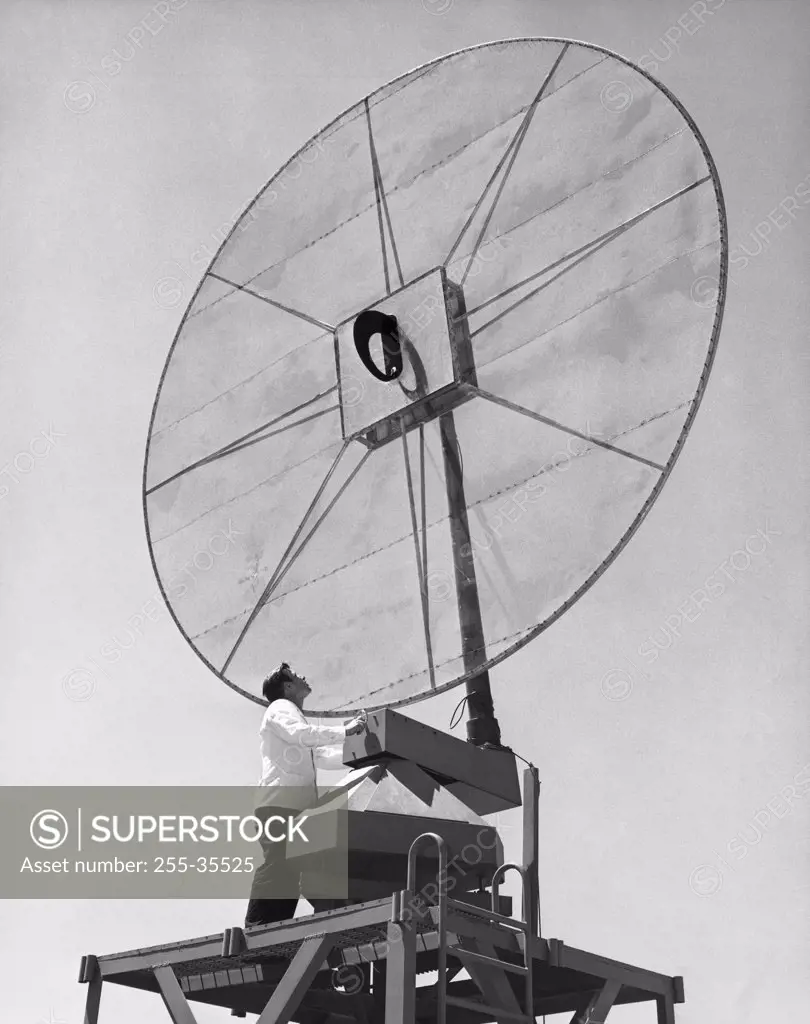 Low angle view of an engineer standing in front of a Scimitar antenna