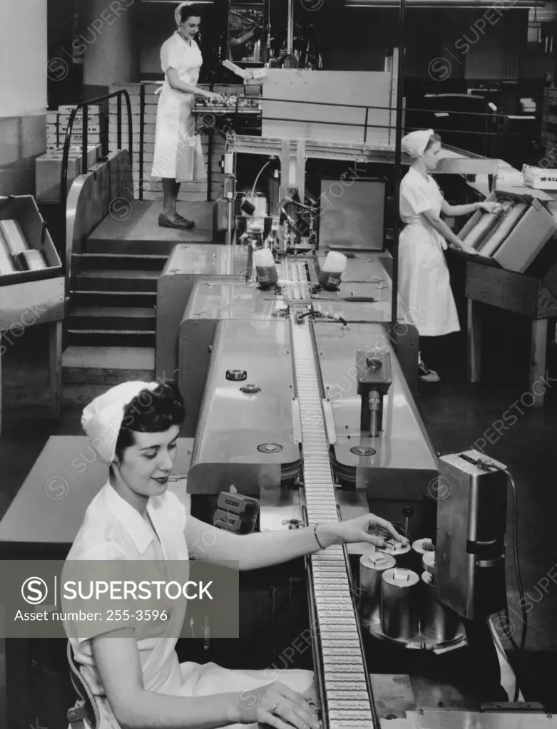 Female workers working on an automatic packaging machine, Rochester, New York State, USA