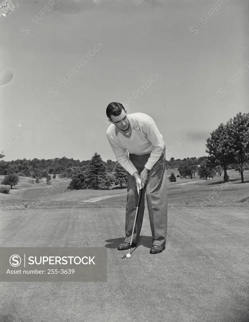 Vintage photograph. Mid adult man playing golf